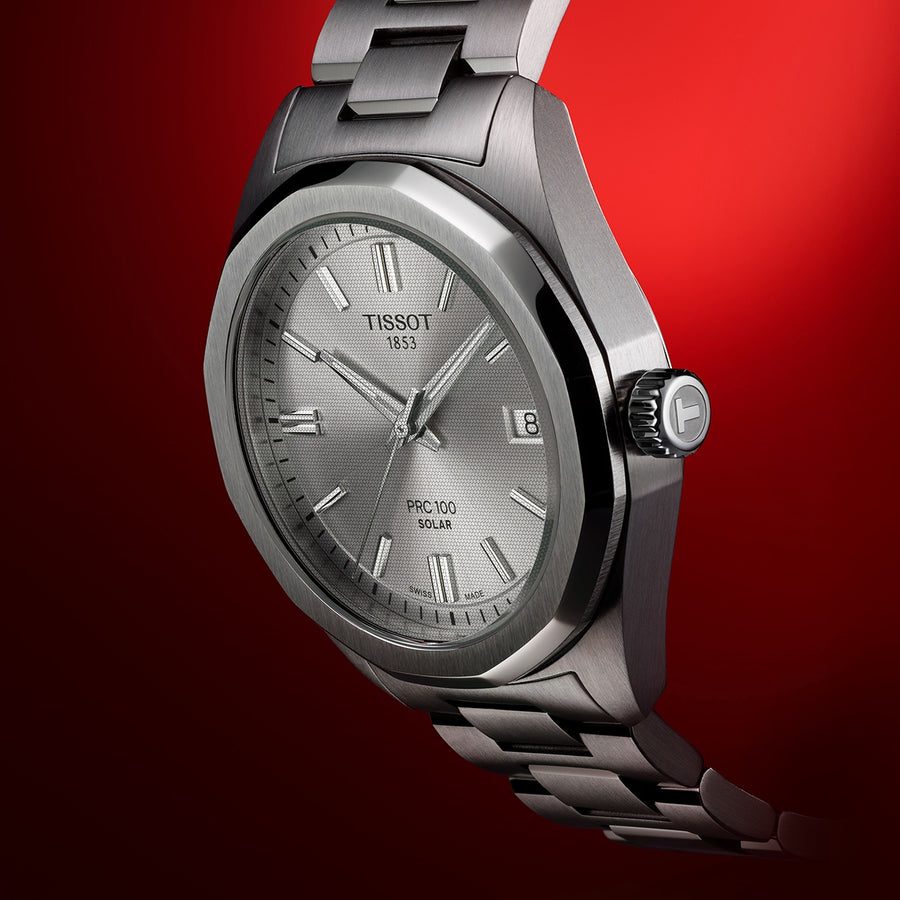 Tissot PRC 100 Solar, cadran argenté en nid d'abeille, date à 3 h, bracelet en acier, sur fond rouge
